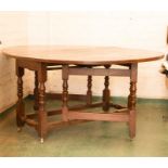 A late 18th century oak gateleg table with turned legs and stretcher.