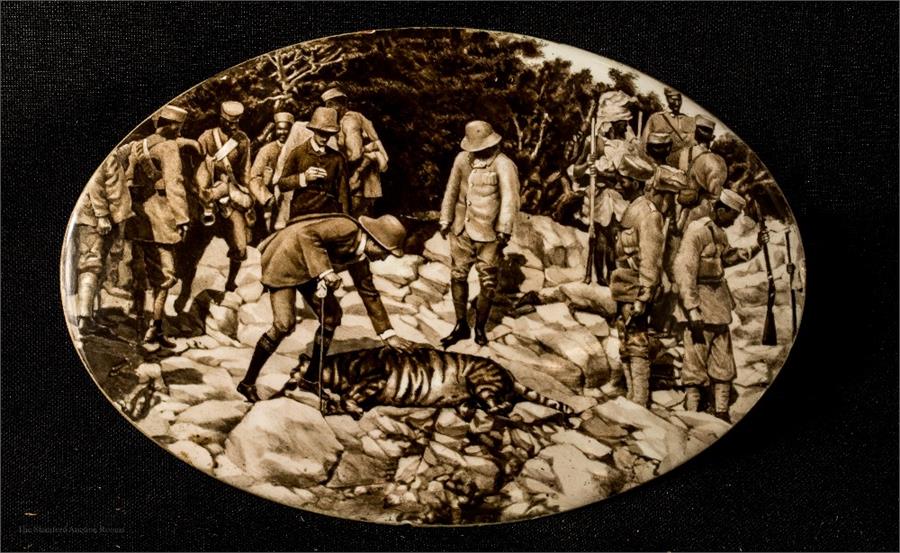 An oval hand painted enamelled plaque depicting a tiger hunt, 15cm long, 10cm wide.