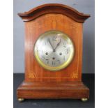 A mahogany mantle clock, inlaid with decoration, three train movement, Arabic dial.