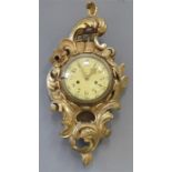 A giltwood Rococo style wall clock, carved with scrollwork bordering the enamel Arabic dial.