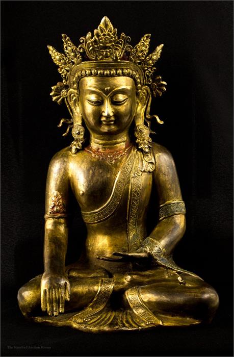 A bronze Buddhist deity, with some original gilding and paintwork, serene pose.