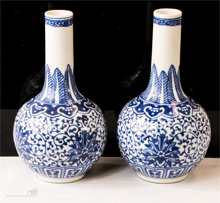 A pair of blue and white bottle vases with seal mark underside.