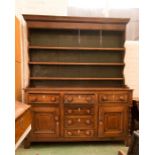 A Georgian oak dresser, the enclosed rack with three shelves above drawers inlaid with decoration.