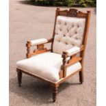 An Edwardian armchair with cream upholstered button back.