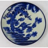 A Japanese wall plate, early 20th century, blue and white depicting birds, rocks, foliage.