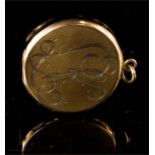 A yellow metal locket, of circular form, engraved with initials and decoration, 10.5g.