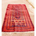 A hand woven prayer mat with red ground.
