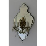 A French mirrored wall sconce, with gilt metal decoration and two branches raising candle form