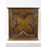 An 18th century oak geometric moulded table cabinet, the single door enclosing an interior of