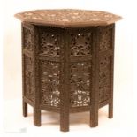 An Indian carved occasional table, the octagonal top carved with grape and vine folding base.