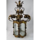 A gilt metal continental lantern, circa 1900 with glass panels and large foliate scrolls.
