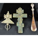 A brass Crucifix, silver plated shoe horn, and an amulet.