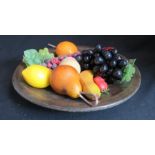 A treen bowl containing model fruit, 38cm diameter.