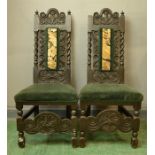 A pair of 18th century chairs, carved with face masks to the top rails, tapestry panel backs and