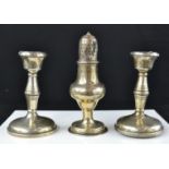 A silver sifter 13cm high, and a pair of silver candle sticks, 11cm high.