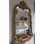 A gilt composition wall mirror.