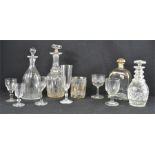 Four cut glass decanters, one decorated with gilding together with a rummer and five other glasses.
