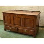 A Georgian oak mule chest, with hinged panel lid, three panel front above two drawers, raised on