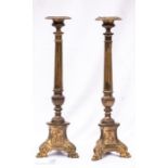 A pair of Ecclesiastical pricket sticks, the fluted columns raised on triform bases,