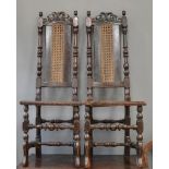 A pair of 18th century Charles II walnut hall chairs with caned back and seats, pierced an scroll