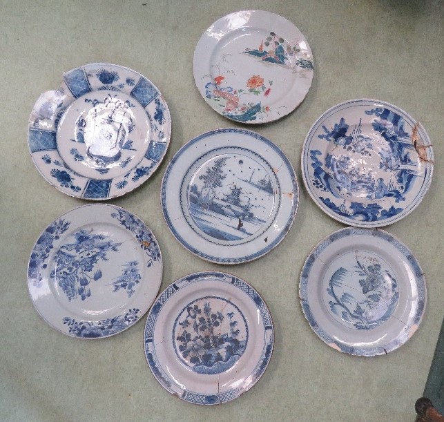 A group of seven chargers/plates, including Delft and Chinese, blue and white and one polychrome.