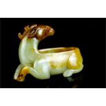 A jade brush wash carved as a ram looking back, rust inclusions.