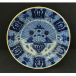 A Delft blue and white plate, with yellow rim, the centre depicting flowers in a vase, signed 300...