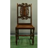 A late 18th century single oak chair with scroll work and panel splat.