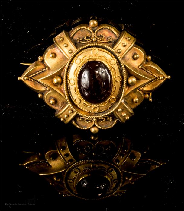 A 19th century yellow metal mourning brooch, with cobochan garnet to the centre.