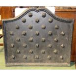 A cast iron fire back, studded, 69 by 27cm.