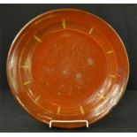 A large 18th century slipware shallow terracotta bowl, 40cm diameter.