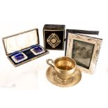 A silver plated salt set in box, silver plated cup and saucer etc.