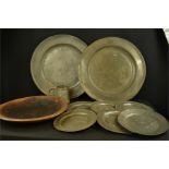 A group of six small pewter plates, two pewter chargers, a treen bowl and a tankard.