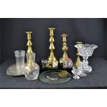 A group of glassware, brass candlesticks, and other items.