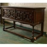 An oak dresser base, 17th century style, with geometric moulded drawers, one with dividers, split