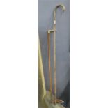 A riding crop and a walking cane with silver metal mount.