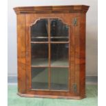 A late 18th/early 19th century walnut corner cupboard with astrigal glazed doors, 92 by 77 by 43cm.