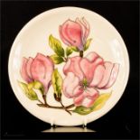 A Moorcroft plate, signed by William Moorcroft to the base, magnolia pattern.