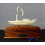 An Indian ivory presentation junk raised on a satinwood box, together with the original certificate,