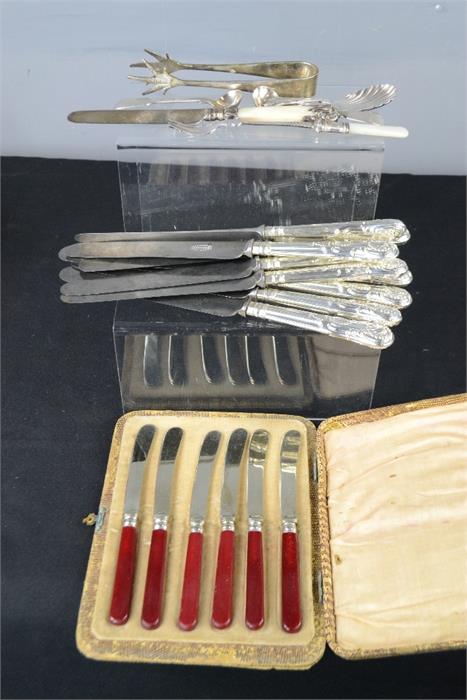 A group of silver plated cutlery, including dinner knives, and a boxed set of butter knives.