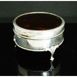 A silver trinket box, of circular form with tortoiseshell lid, raised on three feet, 5cm high, 9cm