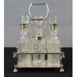 A silver plate cruet set with scroll form supports, cut glass bottles.