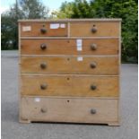 A pine chest of drawers, splits into two sections, two short over three long graduated drawers.