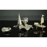 A white metal Chinese miniature boat, a miniature silver plated leaf form chamber stick and