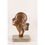 An Art Deco bronze profile portrait of a woman, raised on a marble stand.