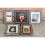 A group of framed African masks, and a Chinese mask.