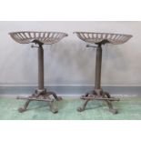 A pair of cast iron tractor seat stools, height adjustable.