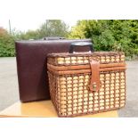 A wicker picnic basket and a leatherette suitcase.