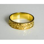 An 18ct gold ring marked 750, the band engraved with flowers, 3.2g.