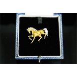 An 18ct gold and diamond horse brooch, the white gold main and tail inset with diamonds, 7.12g.